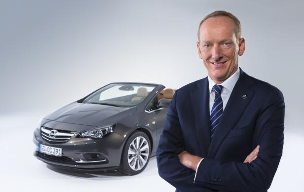 Ein Mann im Anzug steht vor einem grauen Opel Cabriolet.
