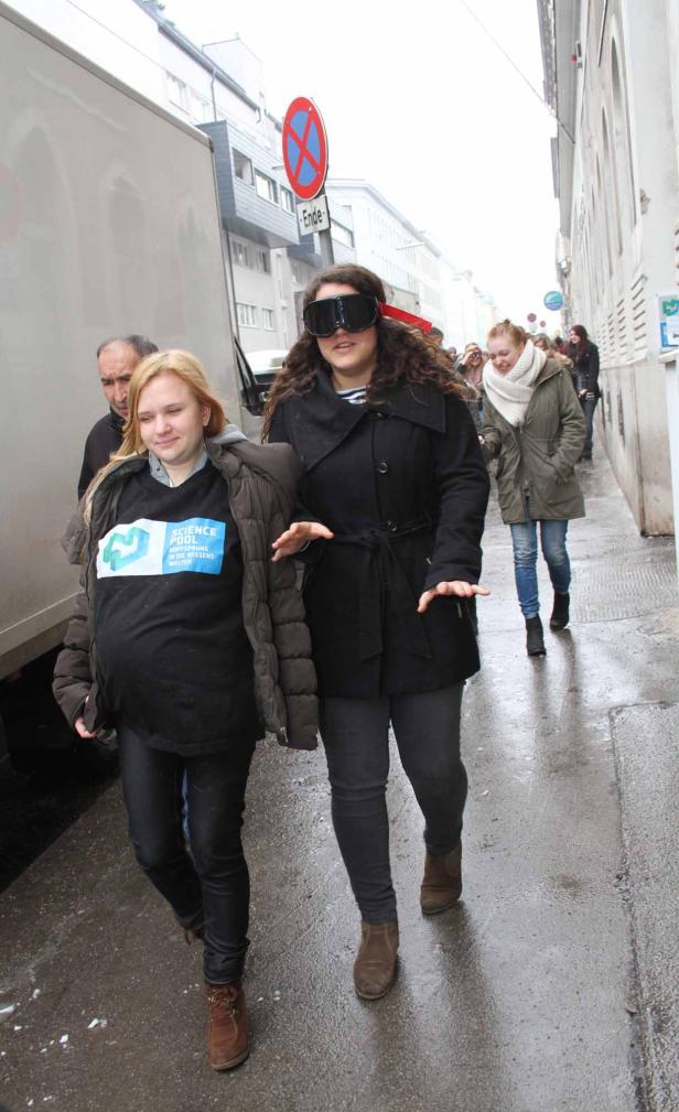 Eine Frau mit übergroßer Brille wird auf einer Straße geführt.