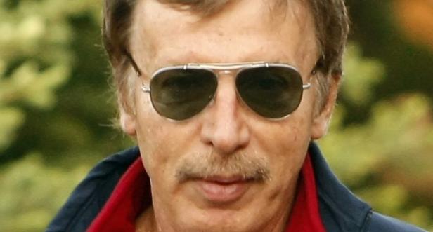 Ein Mann mit Schnurrbart und Pilotenbrille blickt in die Kamera.