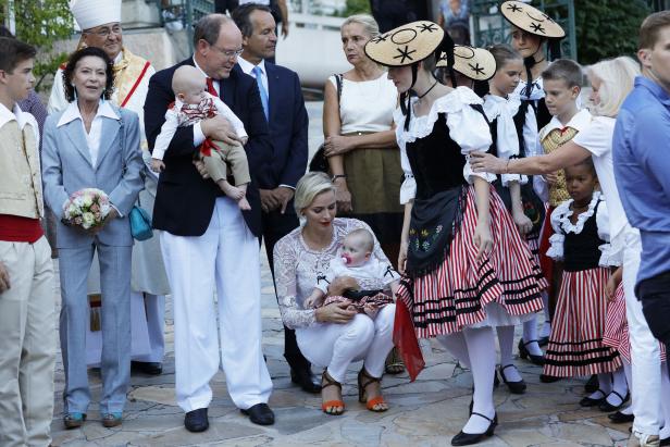 Albert und Charlène von Monaco mit ihren Kindern umgeben von Trachtengruppe.