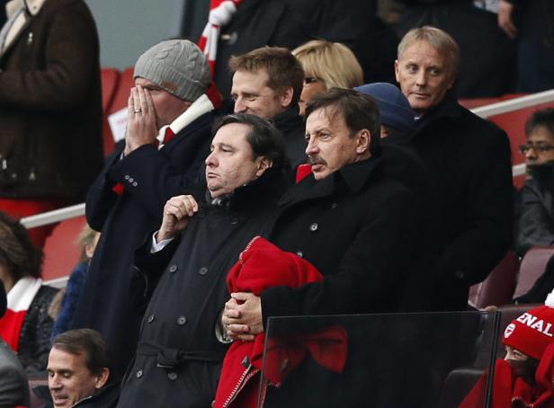 Mehrere Personen, darunter Stan Kroenke, sitzen auf der Tribüne eines Stadions.