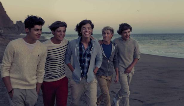 Die Band One Direction geht am Strand entlang.