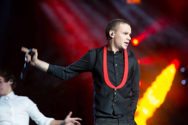 Ein junger Mann mit Mikrofon tritt auf einer Bühne auf.