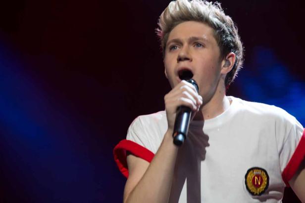 Niall Horan singt während eines Konzerts in ein Mikrofon.