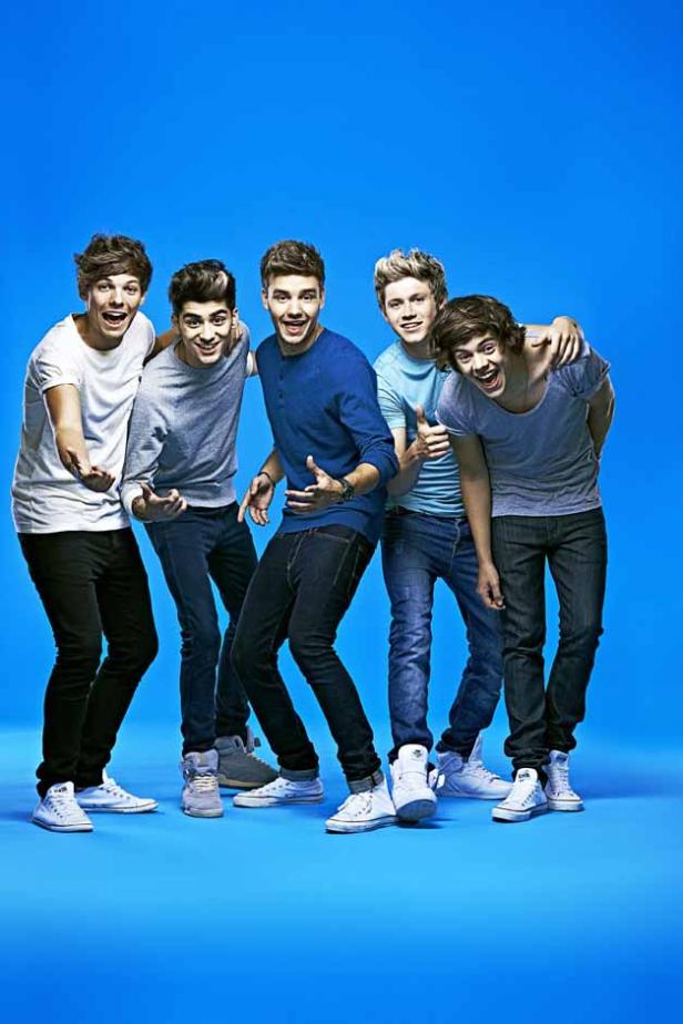 Die Band One Direction posiert vor einem blauen Hintergrund.