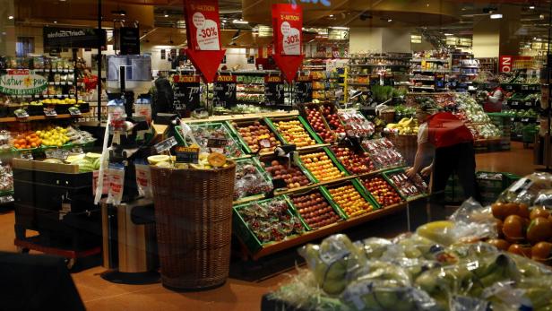 In einem Supermarkt werden verschiedene Obstsorten wie Kirschen, Aprikosen und Pfirsiche angeboten.
