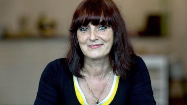 GERMANY LITERATURE Eine Frau mit braunen Haaren und einem schwarzen Oberteil lächelt in die Kamera.