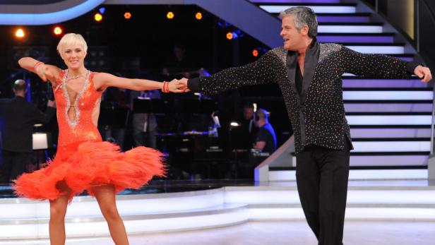 Ein Tanzpaar führt auf einer Bühne einen lateinamerikanischen Tanz auf.