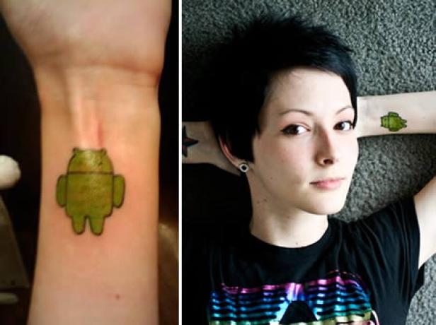 Eine Frau mit einem Tattoo des Android-Logos auf ihrem Arm liegt auf einem Teppich.