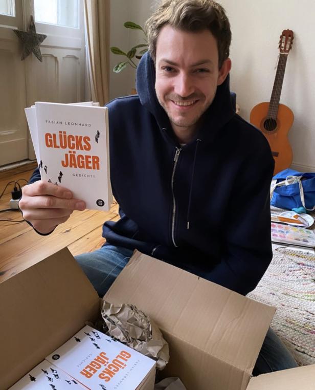 Fabian Leonhard mit seinem 1. Gedichtband „Glücksjäger“ und einer Kiste voller Bücher