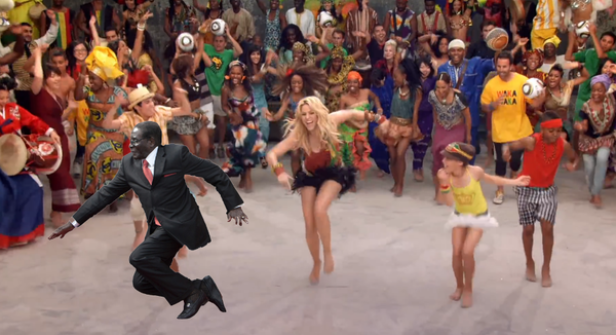 Shakira tanzt mit einer Gruppe von Menschen unterschiedlicher Herkunft, darunter auch Robert Mugabe.