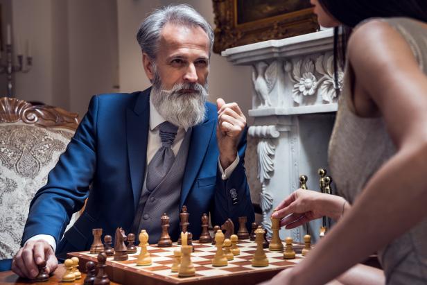 Classy dressed senior man playing chess