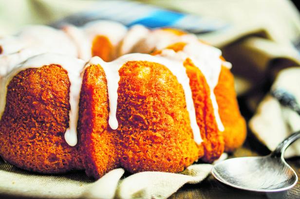 Bundt cake with white glaze on rustic background