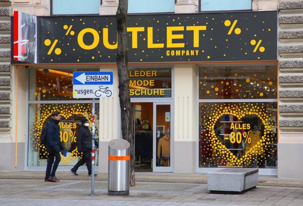 Modehandel: Händler sitzen auf Bergen unverkaufter Ware
