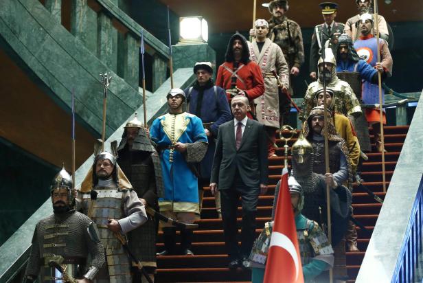 Recep Tayyip Erdoğan geht eine Treppe hinunter, umgeben von historisch gekleideten Wachen.