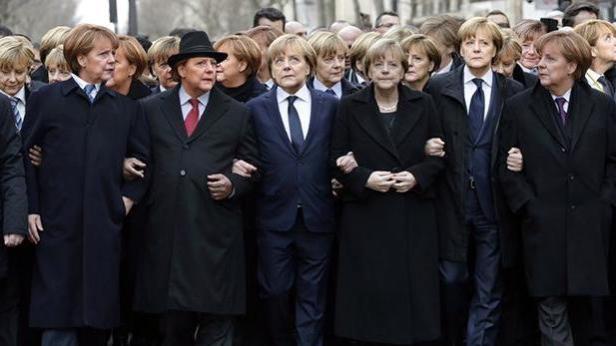 Angela Merkel und andere Personen gehen Arm in Arm.