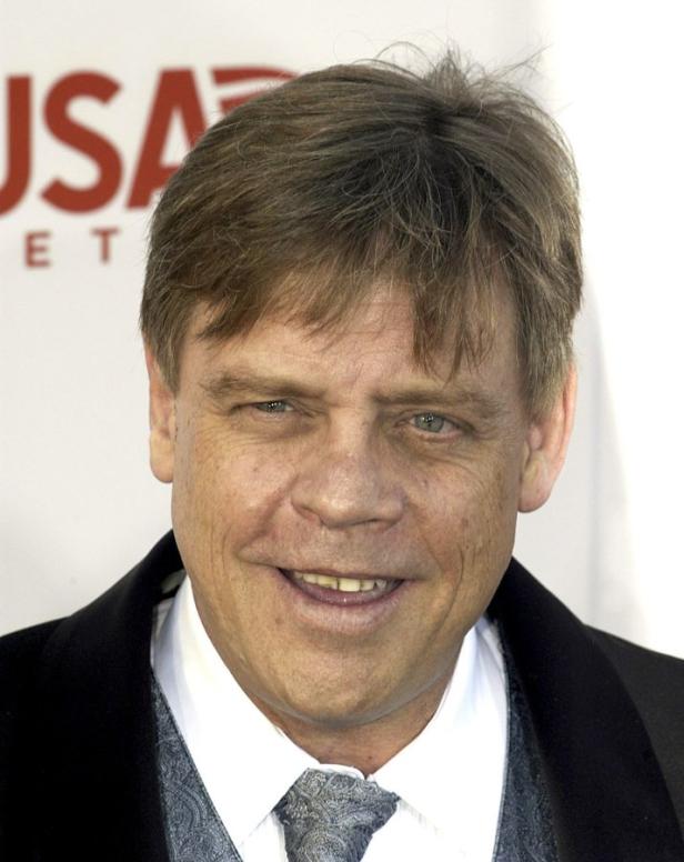 Porträt von Mark Hamill, der lächelt und einen Anzug trägt.