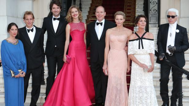 Fürst Albert II. und Charlène von Monaco posieren mit Gästen auf einer Treppe.