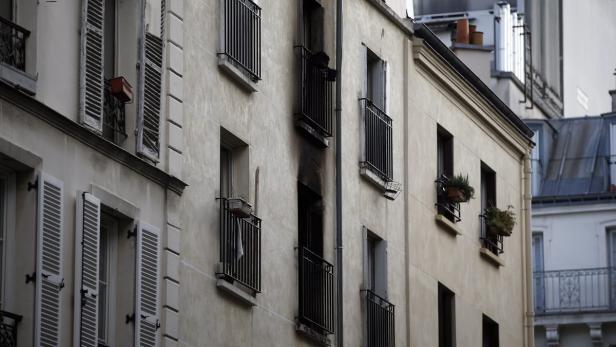 Die Fassade eines Wohnhauses mit Brandspuren um einen Balkon.