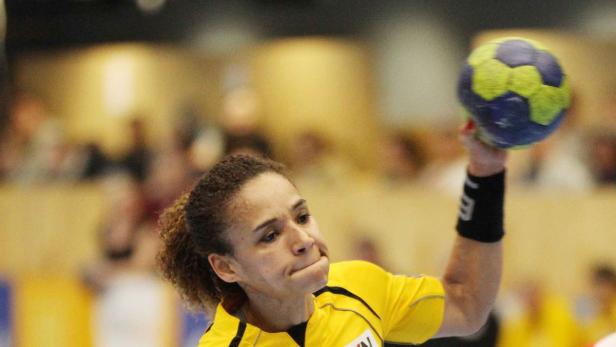 Eine Handballspielerin wirft einen Ball während eines Spiels.