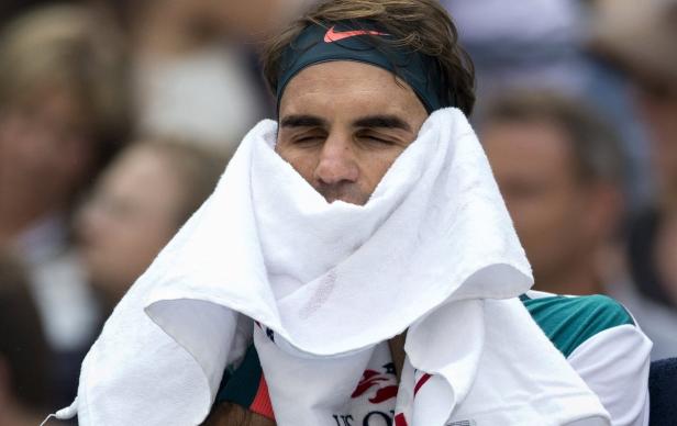 Roger Federer mit einem Handtuch im Gesicht.