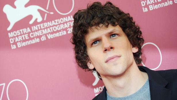 Jesse Eisenberg posiert vor einem Hintergrund der Filmfestspiele von Venedig.