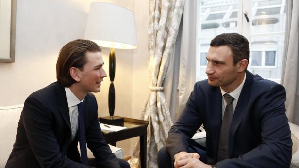 Sebastian Kurz und Vitali Klitschko sitzen in Anzügen und unterhalten sich.