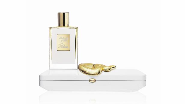 Ein Flakon des Parfüms „In the City of Sin“ von Kilian steht auf einer weißen Schatulle mit goldener Schlange.