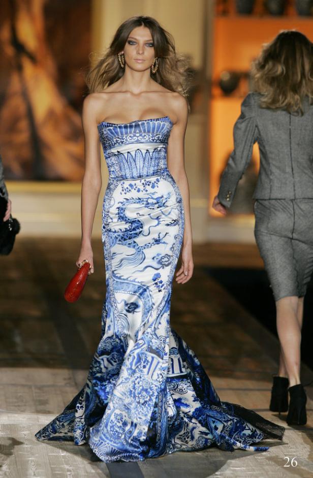 Ein Model präsentiert ein trägerloses, blau-weißes Kleid mit chinesischen Motiven auf dem Laufsteg.