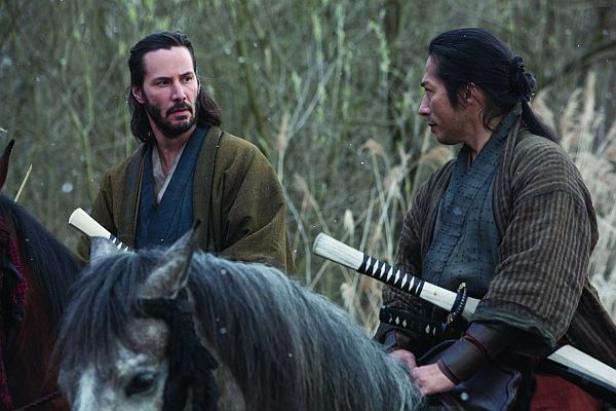Keanu Reeves und ein japanischer Schauspieler reiten als Samurai durch eine winterliche Landschaft.