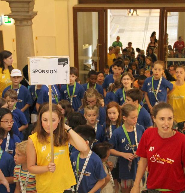 Eine Gruppe Kinder nimmt an einer Sponsionsveranstaltung der Kinderuni Wien teil.