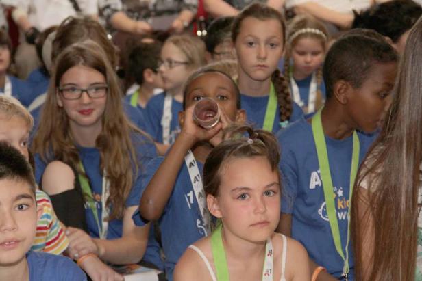 Eine Gruppe von Kindern trägt blaue T-Shirts und grüne Bänder.