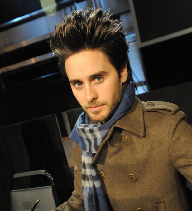 Jared Leto trägt einen braunen Mantel und einen blau-grauen Schal.
