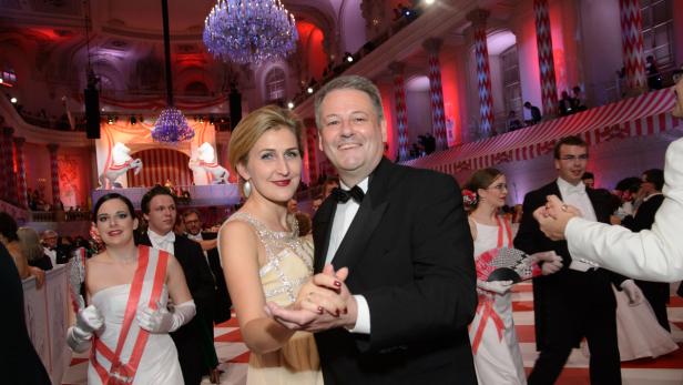 Ein Paar tanzt auf einem festlichen Ball in einem opulenten Saal.