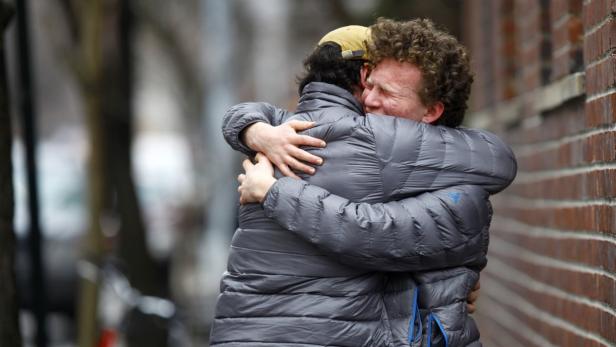 Zwei Männer umarmen sich herzlich auf der Straße.