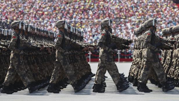 Chinesische Soldaten marschieren in einer Parade vor einer jubelnden Menschenmenge.