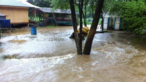 Hochwasser hat ein ländliches Gebiet mit Häusern und Geräten überschwemmt.