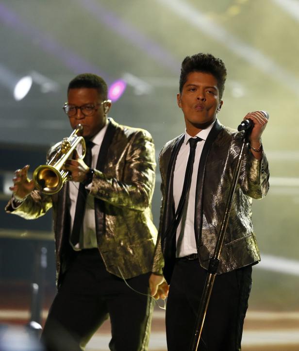 Bruno Mars tritt mit einem Trompeter auf der Bühne auf.