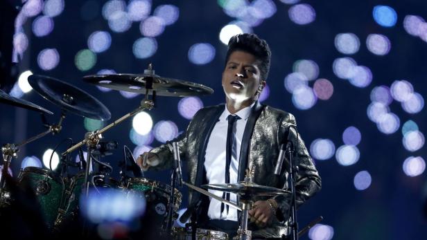 Bruno Mars spielt Schlagzeug bei einem Auftritt.