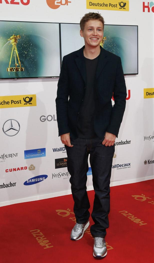 Ein junger Mann auf dem roten Teppich bei einer Preisverleihung.