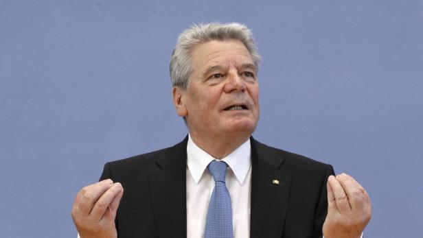 Joachim Gauck gestikuliert vor einem hellblauen Hintergrund.