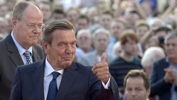 Gerhard Schröder gibt vor einer Menschenmenge den Daumen nach oben.