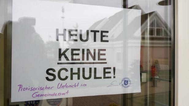 Ein Schild an einer Tür verkündet: „Heute keine Schule! Provisorischer Unterricht im Gemeindeamt“.