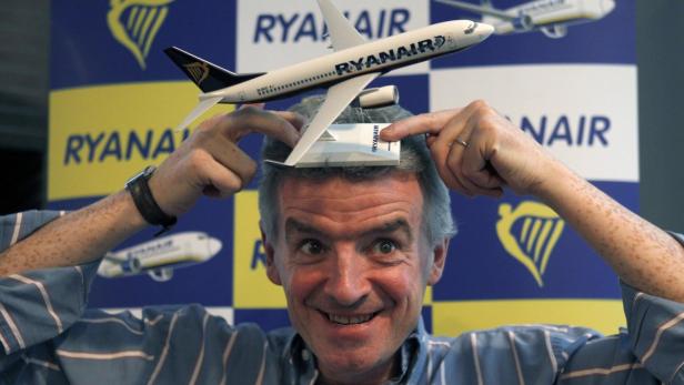 Ein Mann balanciert ein Modellflugzeug von Ryanair auf seinem Kopf.