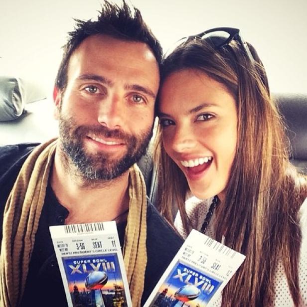 Ein Mann und eine Frau halten Tickets für den Super Bowl XLVIII in der Hand.