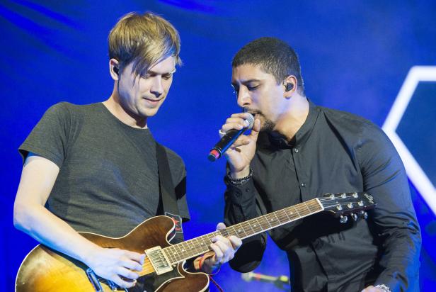 Zwei Musiker treten auf der Bühne mit Gitarre und Mikrofon auf.