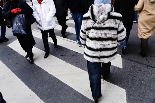 Menschen überqueren einen Zebrastreifen in der Stadt.
