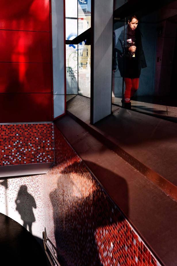 Eine Frau in roter Strumpfhose betritt einen U-Bahnhof.