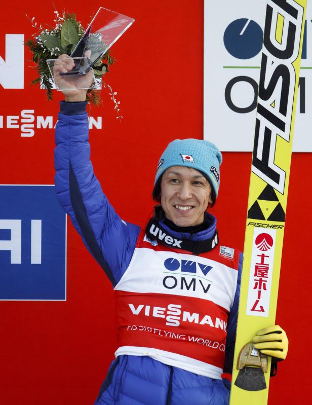 Noriaki Kasai feiert mit einer Trophäe seinen Sieg im Skispringen.