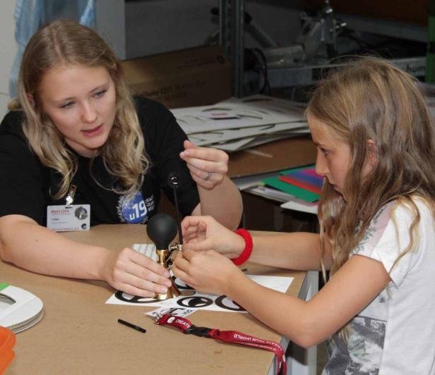 Eine Frau hilft einem Mädchen beim Zusammenbauen eines kleinen Geräts.